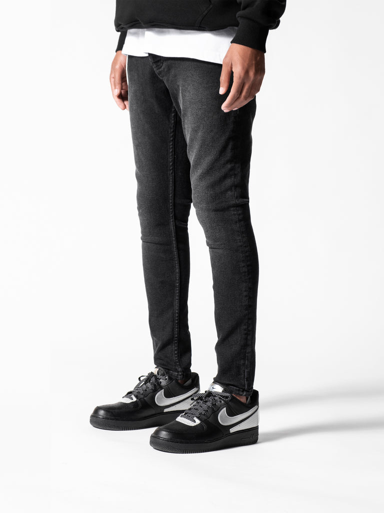 Black Skinny men's denim jeans with nike airforce 1s on  white studio 